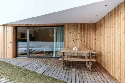 a wooden deck with a bench on a house at Chalet Samont in Laion