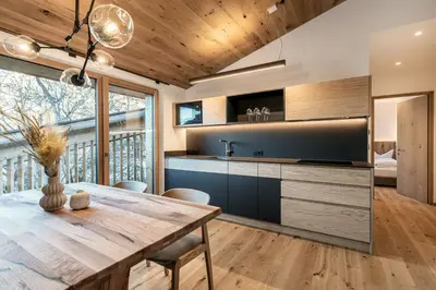 a kitchen with a wooden table and a dining room at Chalet Samont in Laion