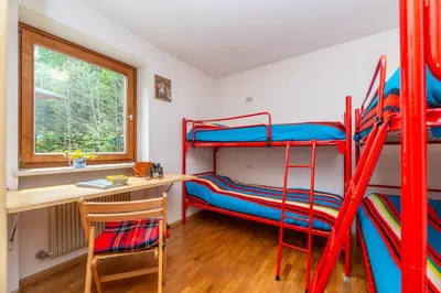 a room with two bunk beds and a desk at Sport & natura in Trentino! in Vigo di Fassa