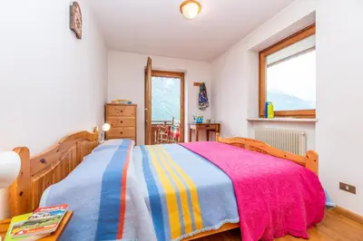 a bedroom with a bed with a colorful blanket at Sport & natura in Trentino! in Vigo di Fassa