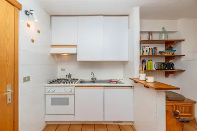 a white kitchen with a sink and a stove at Sport & natura in Trentino! in Vigo di Fassa