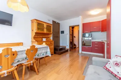 a kitchen and living room with a table and chairs at Residenza Latemar in Moena