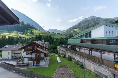 a view of a building with mountains in the background at Residenza Latemar in Moena