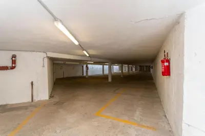 an empty parking garage with a fire hydrant on the wall at Residenza Latemar in Moena