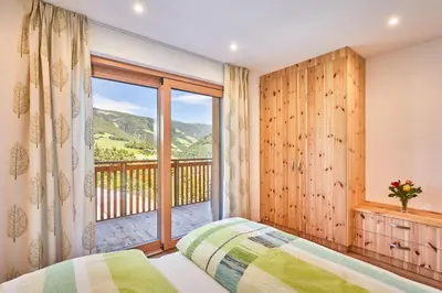a bedroom with a bed and a balcony at Ferienwohnung am Kernhof - Neues Apartment in ruhiger Lage mitten in der Natur - ideal für Paare, Familien, Gäste mit Hunden in Fiumes