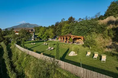 a garden with chairs and a wooden gazebo at Ferienwohnung am Kernhof - Neues Apartment in ruhiger Lage mitten in der Natur - ideal für Paare, Familien, Gäste mit Hunden in Fiumes