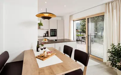 a kitchen and dining room with a wooden table and chairs at Appartement Irene in Caldaro