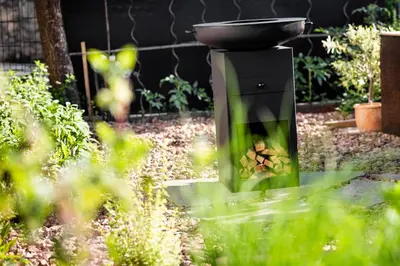 a grill in a garden with a pan on top at Appartement Irene in Caldaro