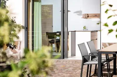 a patio with chairs and a table in a house at Appartement Irene in Caldaro