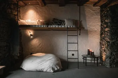 a room with a bunk bed in a cave at Felder Alpin Lodge in Villandro