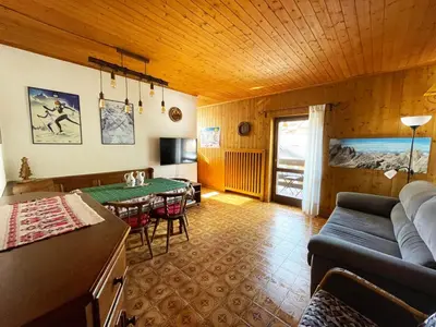 a living room with a couch and a table at La Finestra sui Monti - Alpine Stay Apartments in Cavalese