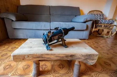 a living room with a couch and a table with a cannon at La Finestra sui Monti - Alpine Stay Apartments in Cavalese
