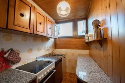 a kitchen with wooden cabinets and a sink at La Finestra sui Monti - Alpine Stay Apartments in Cavalese