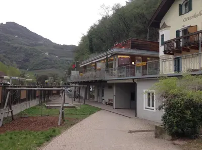 a building with a walkway next to a mountain at Ottenkellerhof in Bolzano