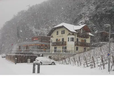 a building with a car parked in the snow at Ottenkellerhof in Bolzano