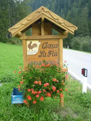 a sign on the side of a road with flowers at Agriturismo La Flu in San Martino in Badia