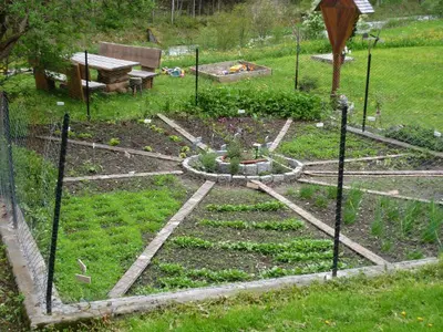 a garden with a fence and some plants in the grass at Agriturismo La Flu in San Martino in Badia
