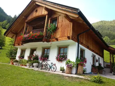 a house with a balcony with flowers on it at Agriturismo La Flu in San Martino in Badia