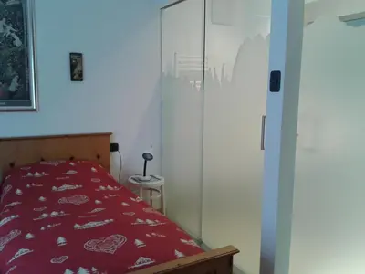 a bedroom with a red bed and a closet at Condominio Zorzi in Moena