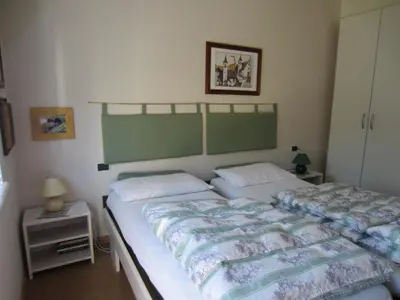 a bedroom with two twin beds and a night stand at Condominio Zorzi in Moena