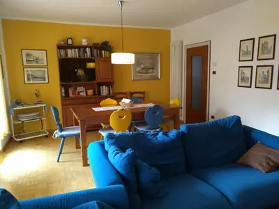 a living room with a blue couch and a table at Condominio Zorzi in Moena