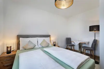 a bedroom with a bed with two chairs and a table at Lothof in Schenna