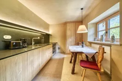a kitchen with a table and a counter with a sink at Lothof in Schenna