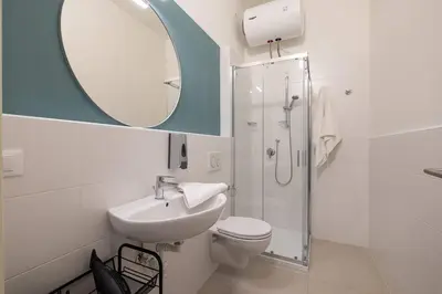 a bathroom with a sink and a toilet and a mirror at Mia Rooms - Zimmer mit Privatbad Bozen Zentrum01 in Bolzano