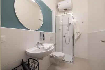 a bathroom with a sink and a toilet and a mirror at Mia Rooms - Room with private bath Bolzano Center in Bolzano