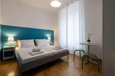 a bedroom with a large bed with a blue wall at Mia Rooms - Room with private bath Bolzano Center in Bolzano