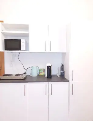 a kitchen counter with white cabinets and a microwave at Mia Rooms - Room with private bath Bolzano Center in Bolzano