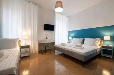 a bedroom with two beds and a blue wall at Mia Rooms - Room with Private Bath Bolzano Center01 in Bolzano