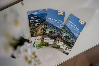three brochures on top of a table at Mia Rooms - Room with Private Bath Bolzano Center01 in Bolzano