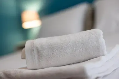 a rolled up towel sitting on top of a bed at Mia Rooms - Room with Private Bath Bolzano Center01 in Bolzano