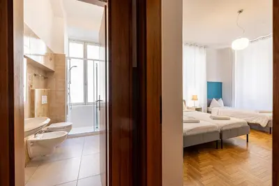 a bathroom with a toilet and a sink and a bed at Mia Rooms - Room with Private Bath Bolzano Center in Bolzano