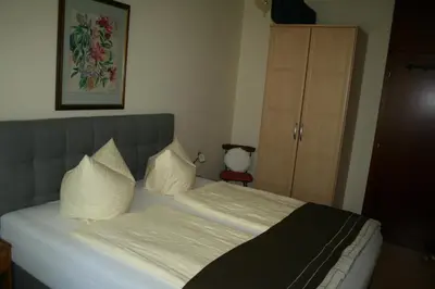 a bedroom with a bed with white sheets and pillows at Ferienwohnung Thermen in Merano
