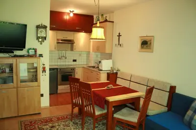 a living room with a table and a kitchen at Ferienwohnung Thermen in Merano