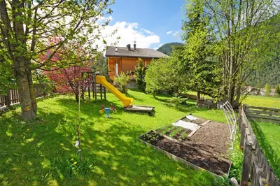 a yard with a playground and a house at Pension Arnica B&B in San Vigilio Di Marebbe