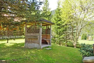 a wooden gazebo sitting in the middle of a yard at Pension Arnica B&B in San Vigilio Di Marebbe