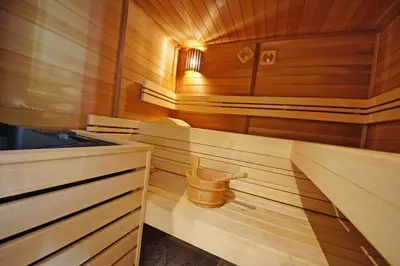 a small wooden sauna with a bucket in it at Pension Arnica B&B in San Vigilio Di Marebbe