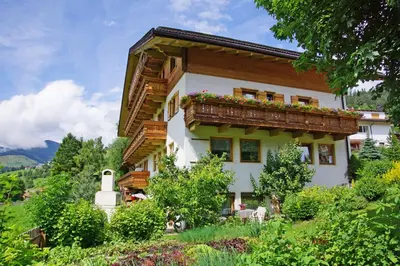 a house with a balcony with flowers on it at Pension Arnica B&B in San Vigilio Di Marebbe