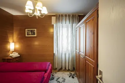 a bedroom with a red bed and a window at Villa Ginestra 3 in Moena