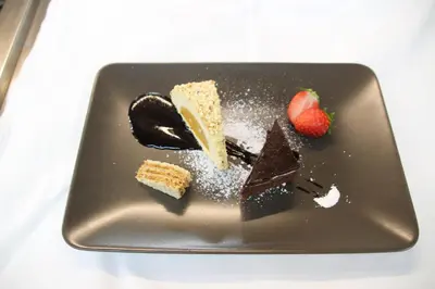 a plate with chocolate cake and a strawberry on it at Hotel Pörnbacher in Valdaora