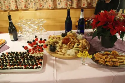 a table with a plate of food and bottles of wine at Hotel Pörnbacher in Valdaora