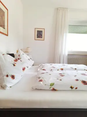 a bed with white sheets and pillows with a window at Café Rudi Living in Parcines