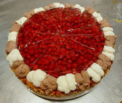 a cake with strawberries and ice cream on a table at Café Rudi Living in Parcines