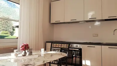 a kitchen with a counter and a table with flowers on it at Café Rudi Living in Parcines
