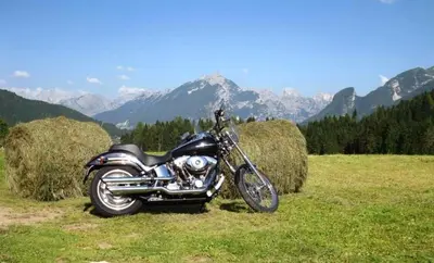 a motorcycle parked in a field next to hay bales at Café Rudi Living in Parcines