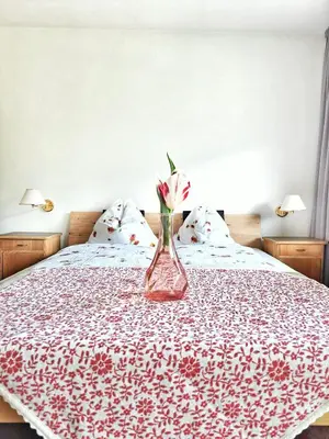 a vase with a flower sitting on top of a bed at Café Rudi Living in Parcines