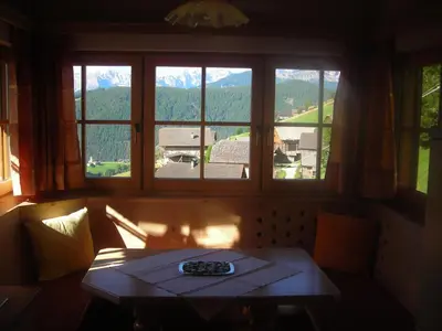 a room with a table and a large window at Casa Gogn in San Vigilio Di Marebbe